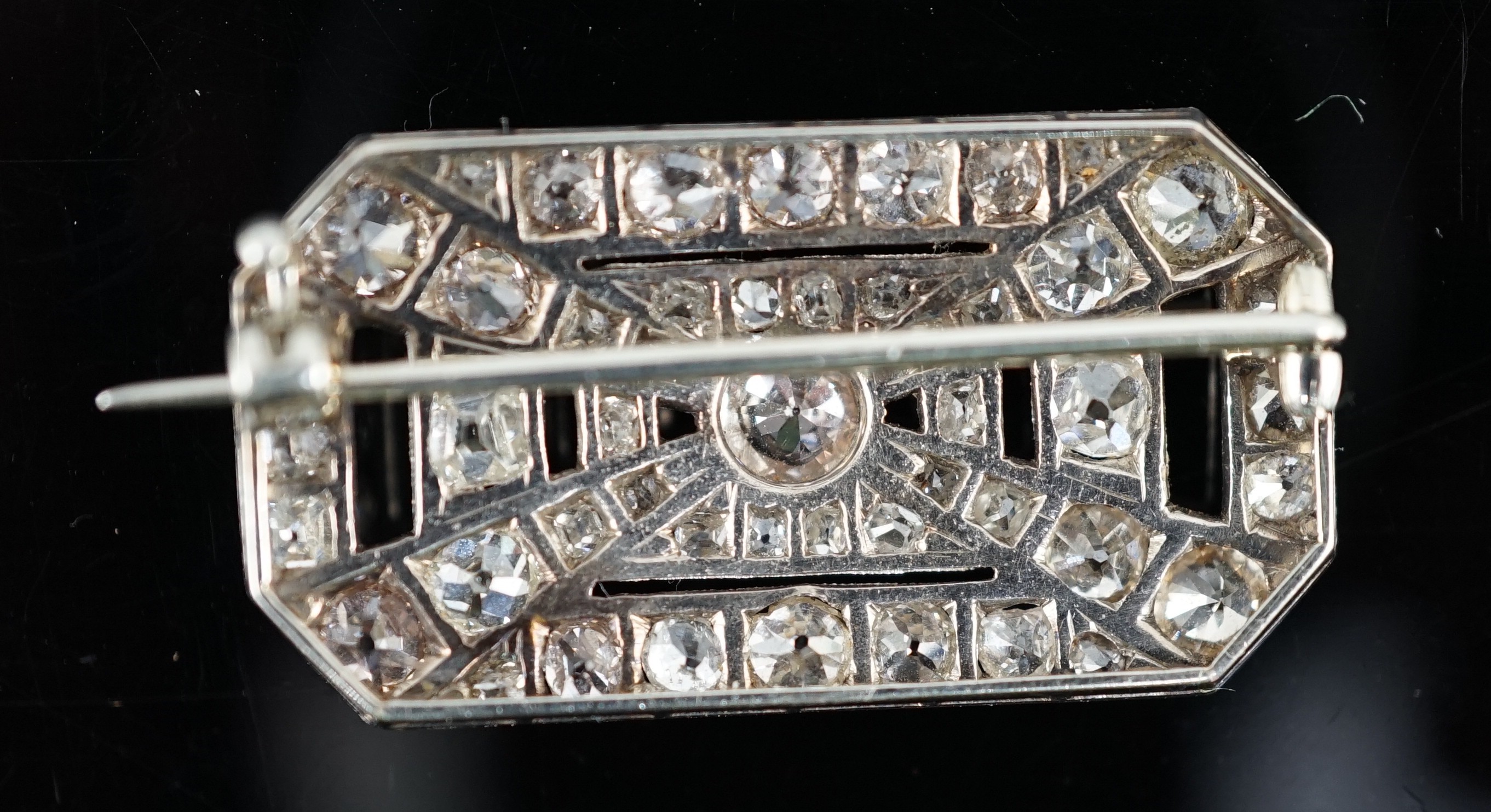 A 1930's/1940's Art Deco white gold, platinum and graduated diamond cluster millegrain set octagonal brooch